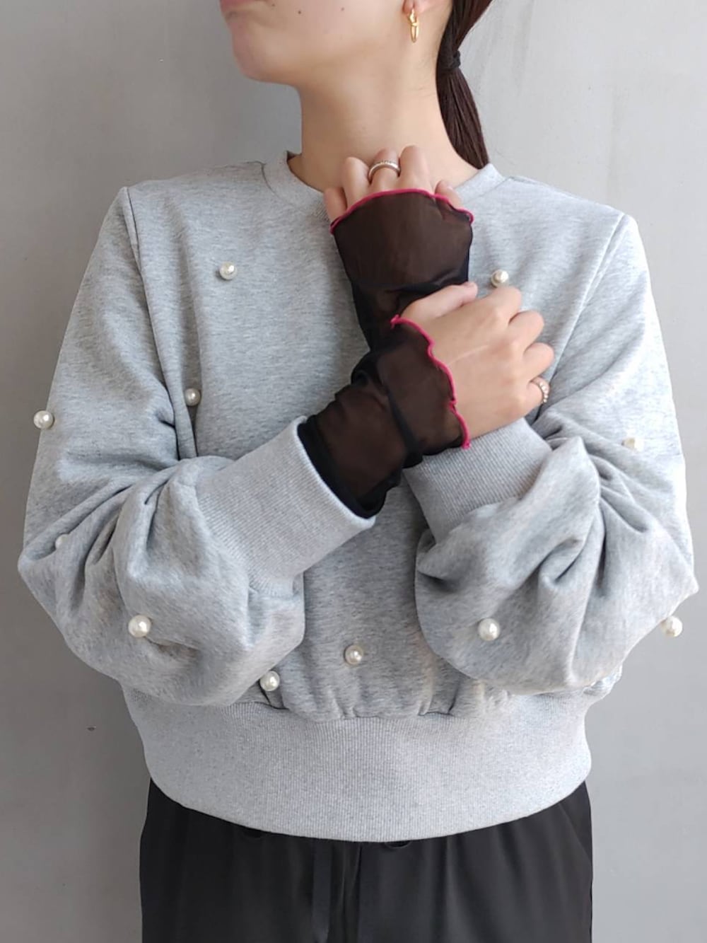 グレー系のスウェット、オレンジ系のハンドバッグ、ホワイト系のスニーカーを着用したレディースの秋コーディネートの2枚目の写真