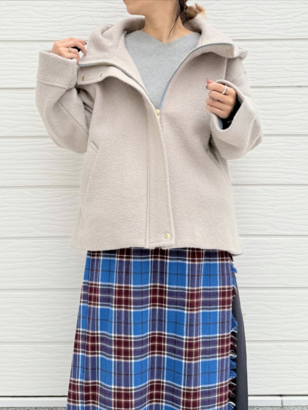 ブルー系のスカート、ブラック系のブーツ、ベージュ系のその他アウターを着用したレディースの秋コーディネートの3枚目の写真