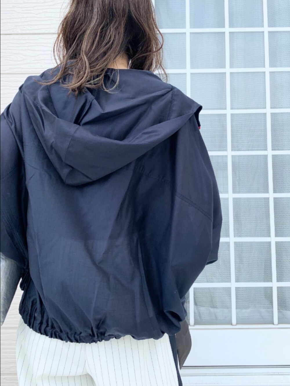 ホワイト系のその他パンツ、ブルー系のブルゾン、ブラック系のキャミソールを着用したレディースの春コーディネートの4枚目の写真