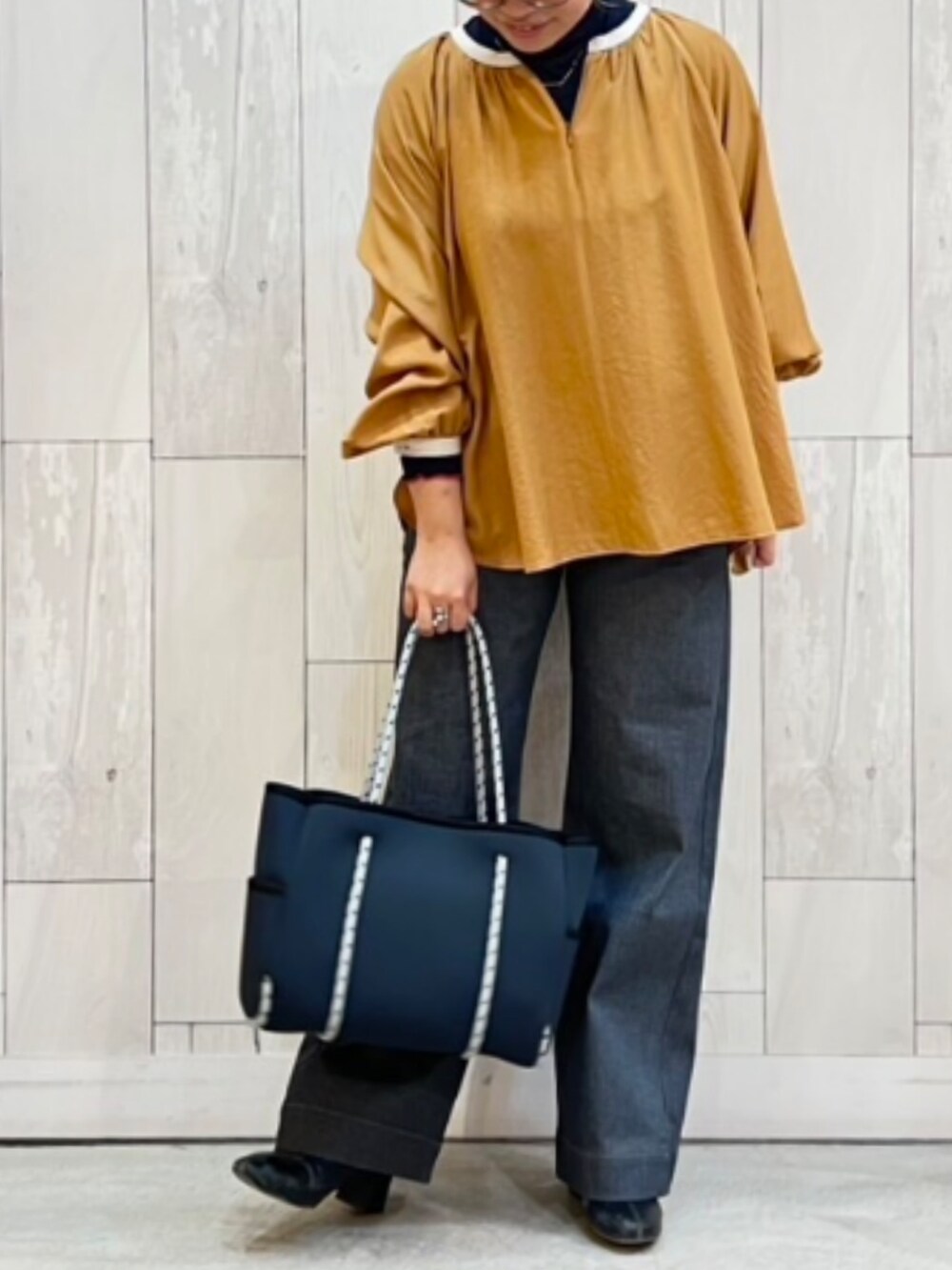 ブルー系のトートバッグ、グレー系のデニムパンツ、ブラウン系のシャツ/ブラウスを着用したレディースの冬コーディネートの2枚目の写真