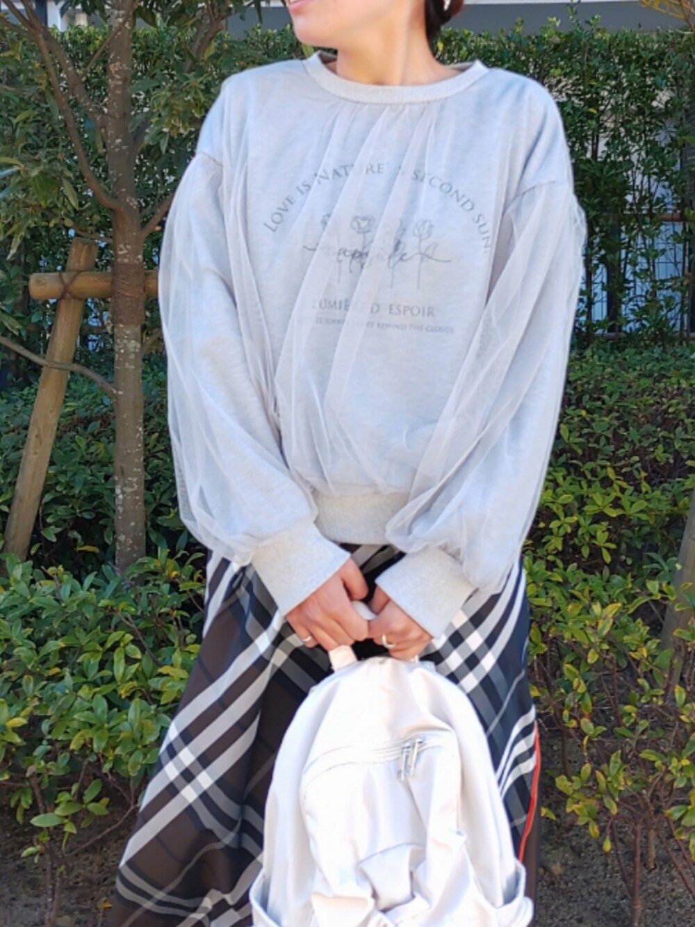 ホワイト系のバックパック/リュック、ブラウン系のスカート、ホワイト系のスニーカーを着用したレディースの秋コーディネートの4枚目の写真