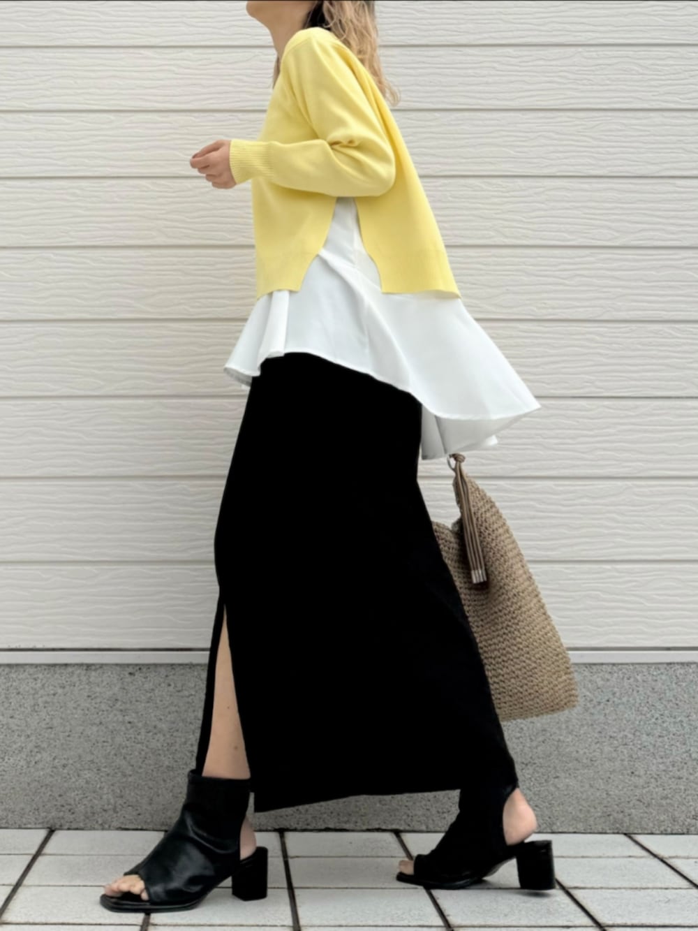 ブラック系のサンダル、ブラック系のスカート、ベージュ系のトートバッグを着用したレディースの冬コーディネートの3枚目の写真