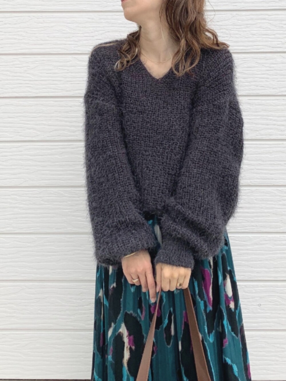 グリーン系のスカート、ブラック系のスニーカー、グレー系のニット/セーターを着用したレディースの秋コーディネートの4枚目の写真