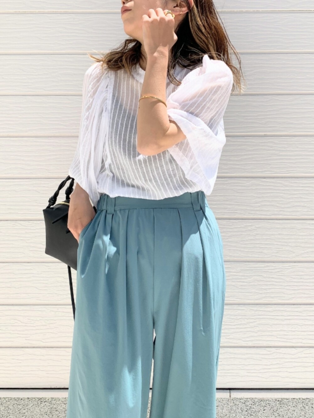 ホワイト系のシャツ/ブラウス、ブルー系のその他パンツ、ブラック系のハンドバッグを着用したレディースの春コーディネートの4枚目の写真