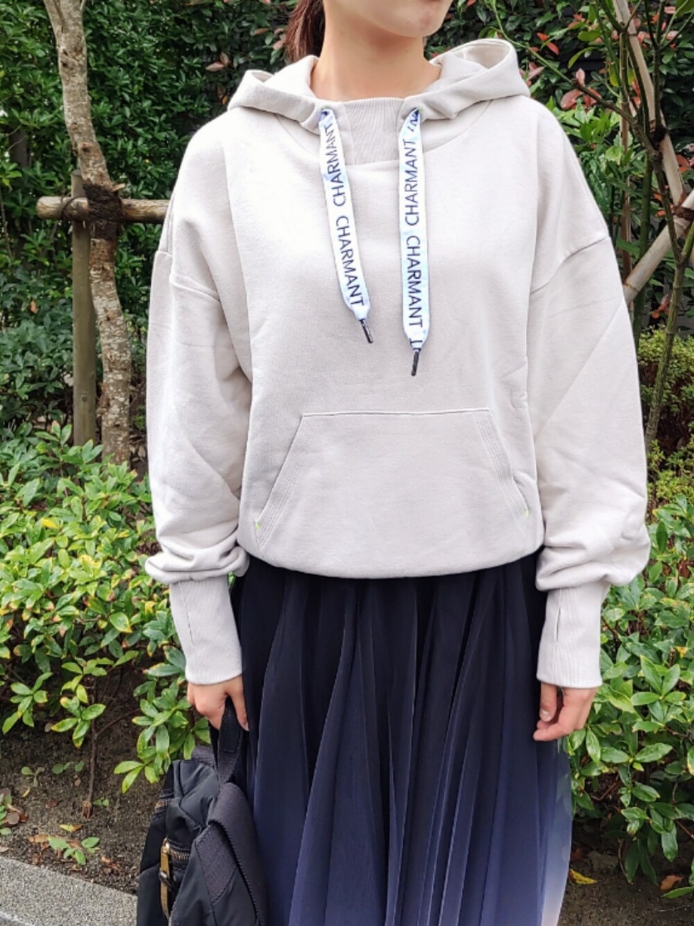 ブラック系のスカート、ベージュ系のパーカー、ホワイト系のスニーカーを着用したレディースの秋コーディネートの4枚目の写真