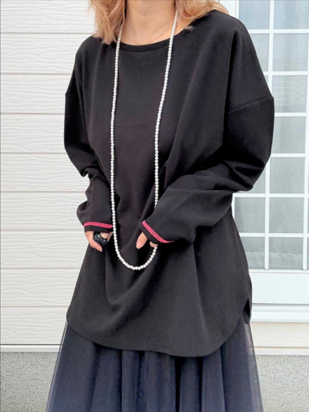 ブラック系のTシャツ/カットソー、ブラック系のスカート、ホワイト系のスニーカーを着用したレディースの秋コーディネートの4枚目の写真