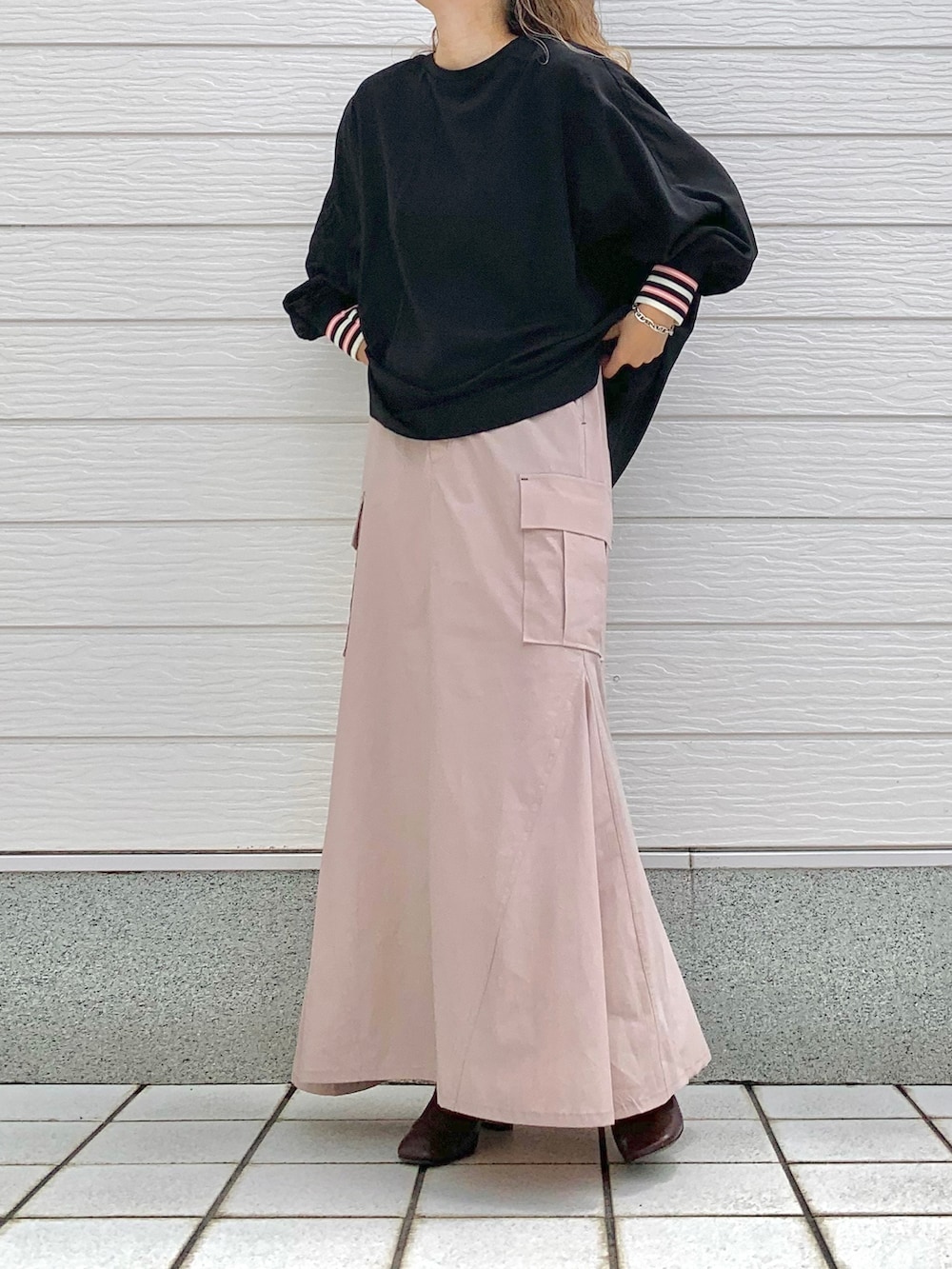 ブラック系のシャツ/ブラウス、ピンク系のスカート、ブラウン系のブーツを着用したレディースの夏コーディネートの3枚目の写真