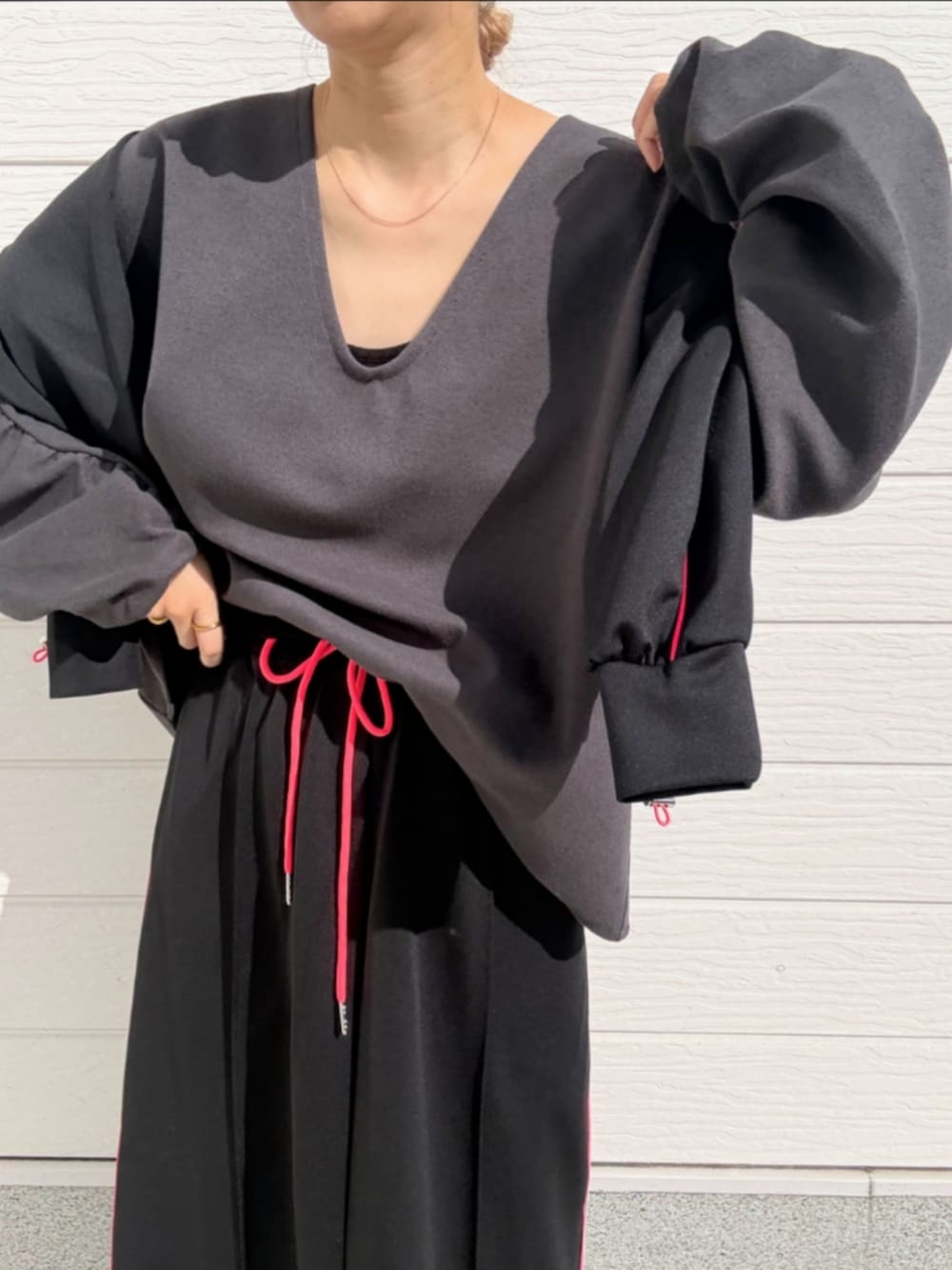 ブラック系のスカート、グレー系のTシャツ/カットソー、ホワイト系のスニーカーを着用したレディースの春コーディネートの5枚目の写真