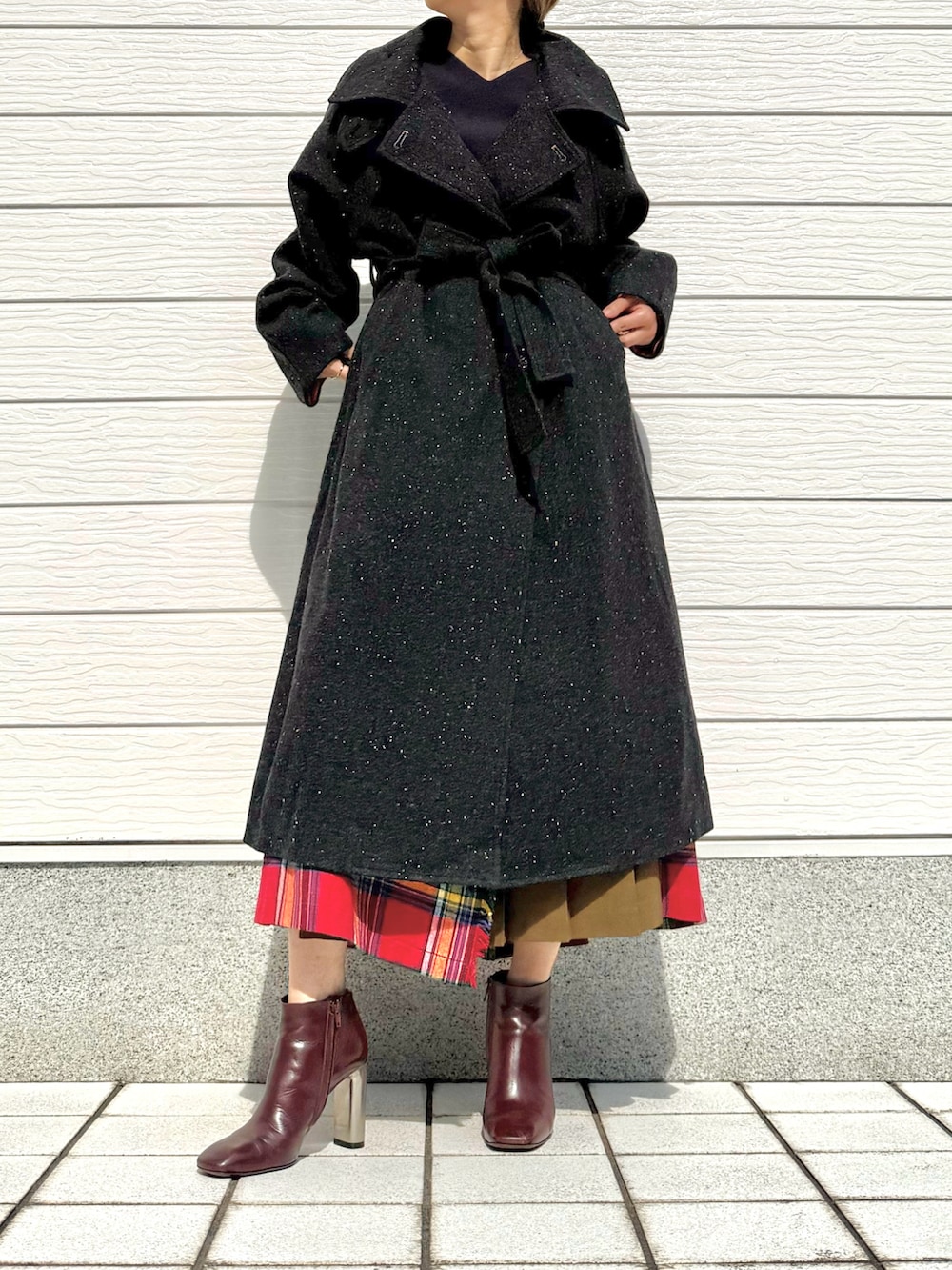 ブラウン系のブーツ、レッド系のスカート、ブルー系のニット/セーターを着用したレディースの秋コーディネートの2枚目の写真