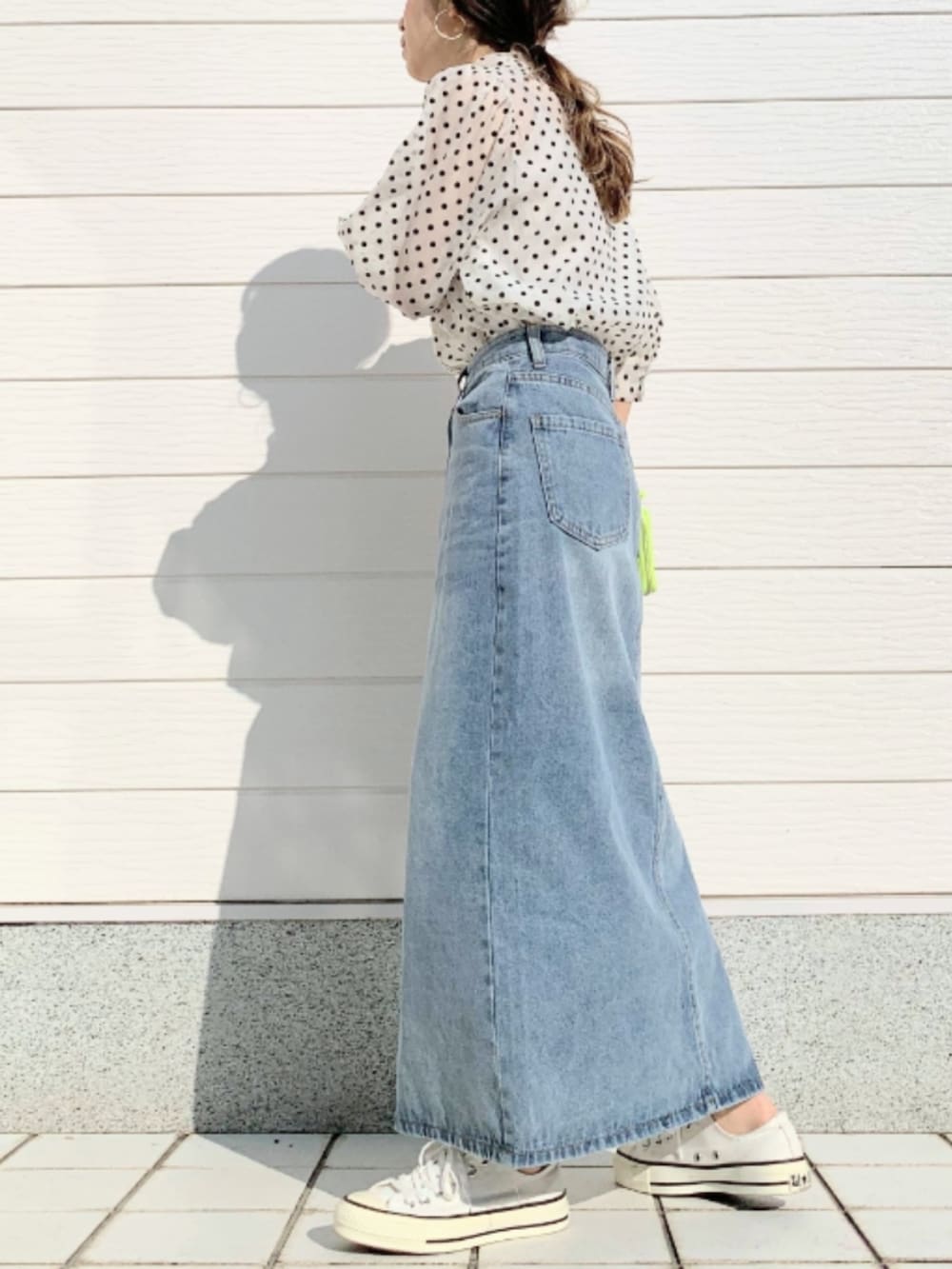 ブルー系のデニムスカート、ホワイト系のスニーカー、ベージュ系のシャツ/ブラウスを着用したレディースの春コーディネートの2枚目の写真