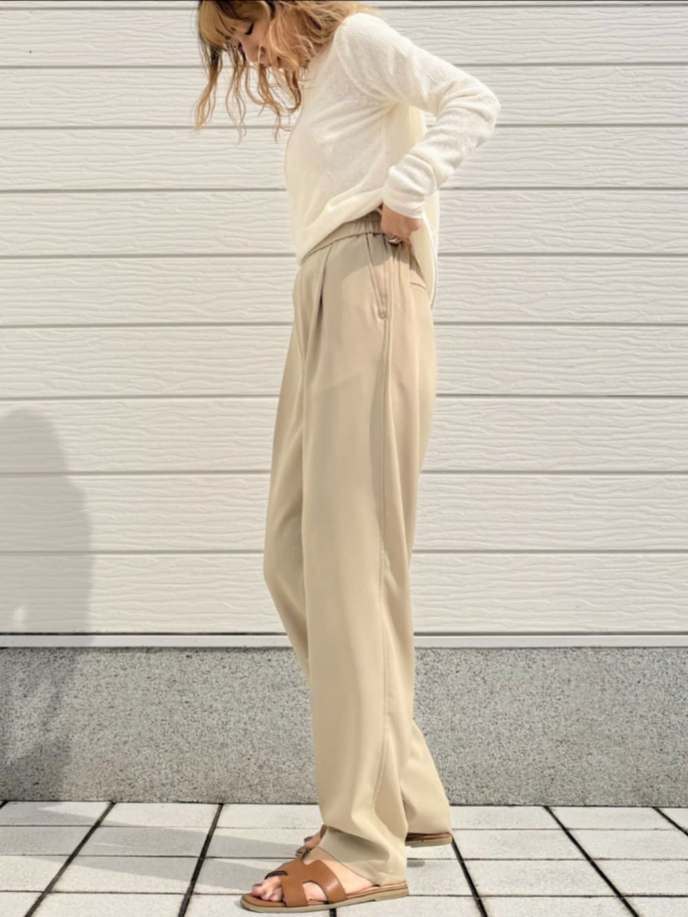 ベージュ系のその他パンツ、ホワイト系のTシャツ/カットソー、イエロー系のサンダルを着用したレディースの冬コーディネートの2枚目の写真