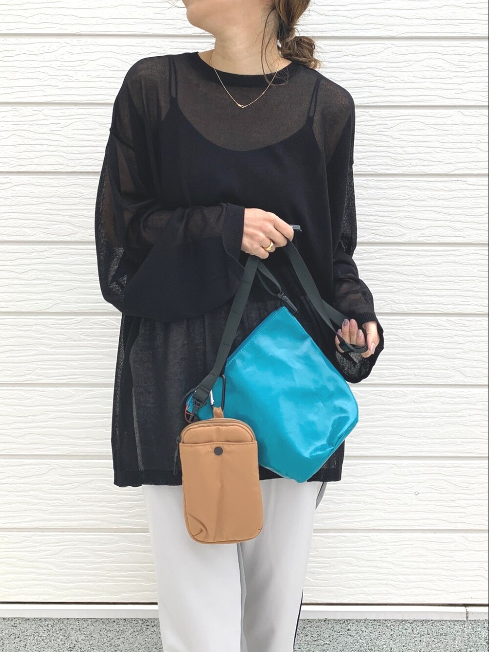 ブラック系のニット/セーター、グリーン系のショルダーバッグ、グレー系のその他パンツを着用したレディースの春コーディネートの4枚目の写真