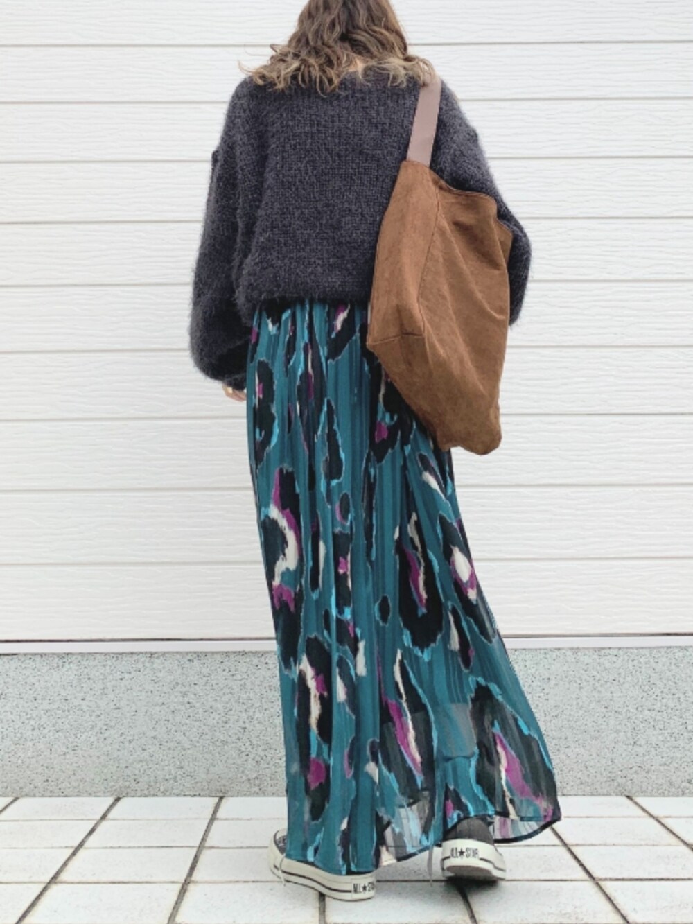 グリーン系のスカート、ブラック系のスニーカー、グレー系のニット/セーターを着用したレディースの秋コーディネートの3枚目の写真