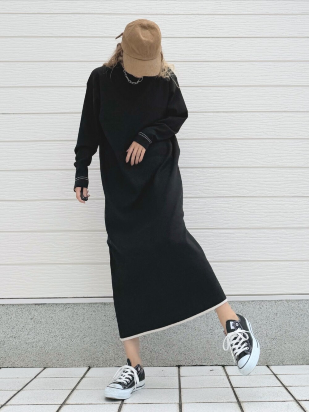 ブラック系のスニーカー、ブラック系のワンピース、ホワイト系のストール/ショールを着用したレディースの秋コーディネートの2枚目の写真