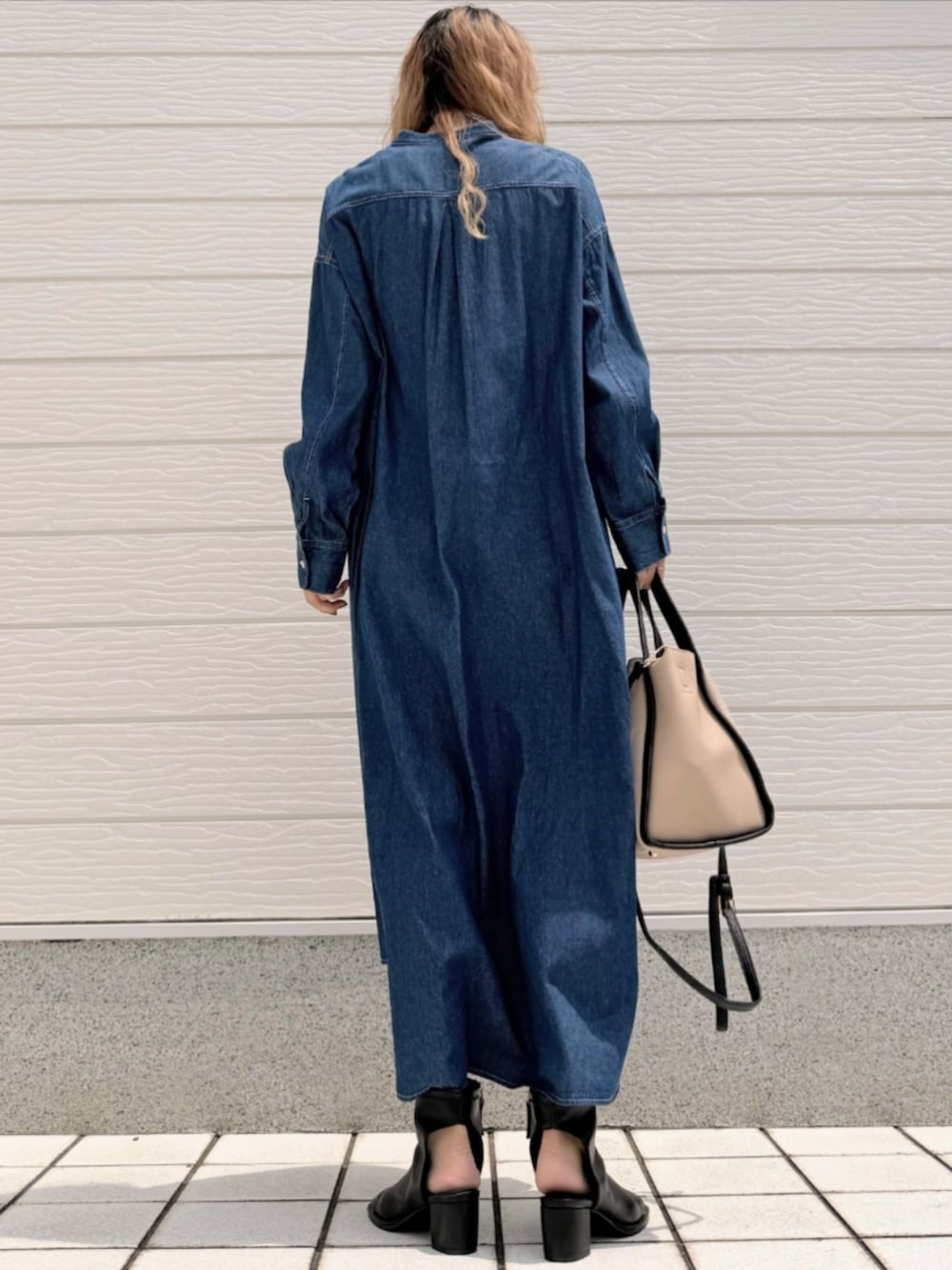 ブラック系のサンダル、ブルー系のシャツワンピース、ベージュ系のハンドバッグを着用したレディースの夏コーディネートの3枚目の写真