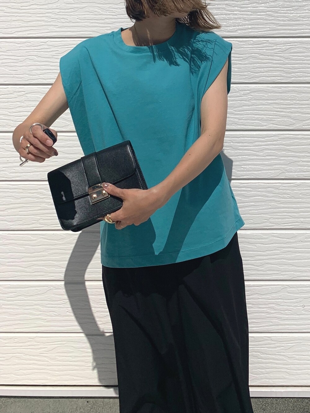 ブラック系のサンダル、ブラック系のその他パンツ、グリーン系のTシャツ/カットソーを着用したレディースの夏コーディネートの3枚目の写真
