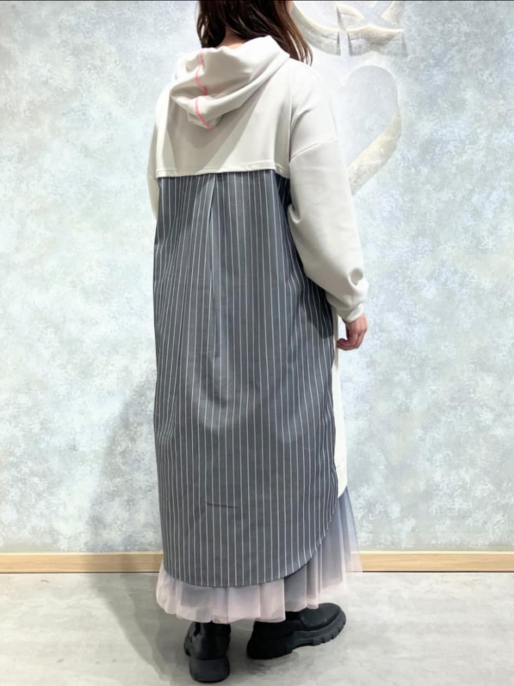 ホワイト系のワンピース、ブラック系のスカートを着用したレディースの冬コーディネートの2枚目の写真