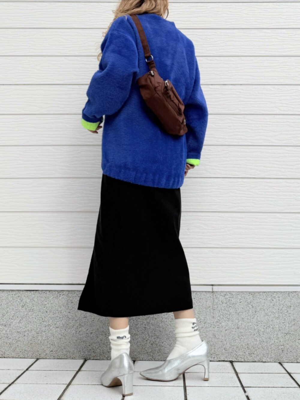 ブラック系のスカート、ブルー系のカーディガン/ボレロ、ブラック系のTシャツ/カットソーを着用したレディースの秋コーディネートの3枚目の写真