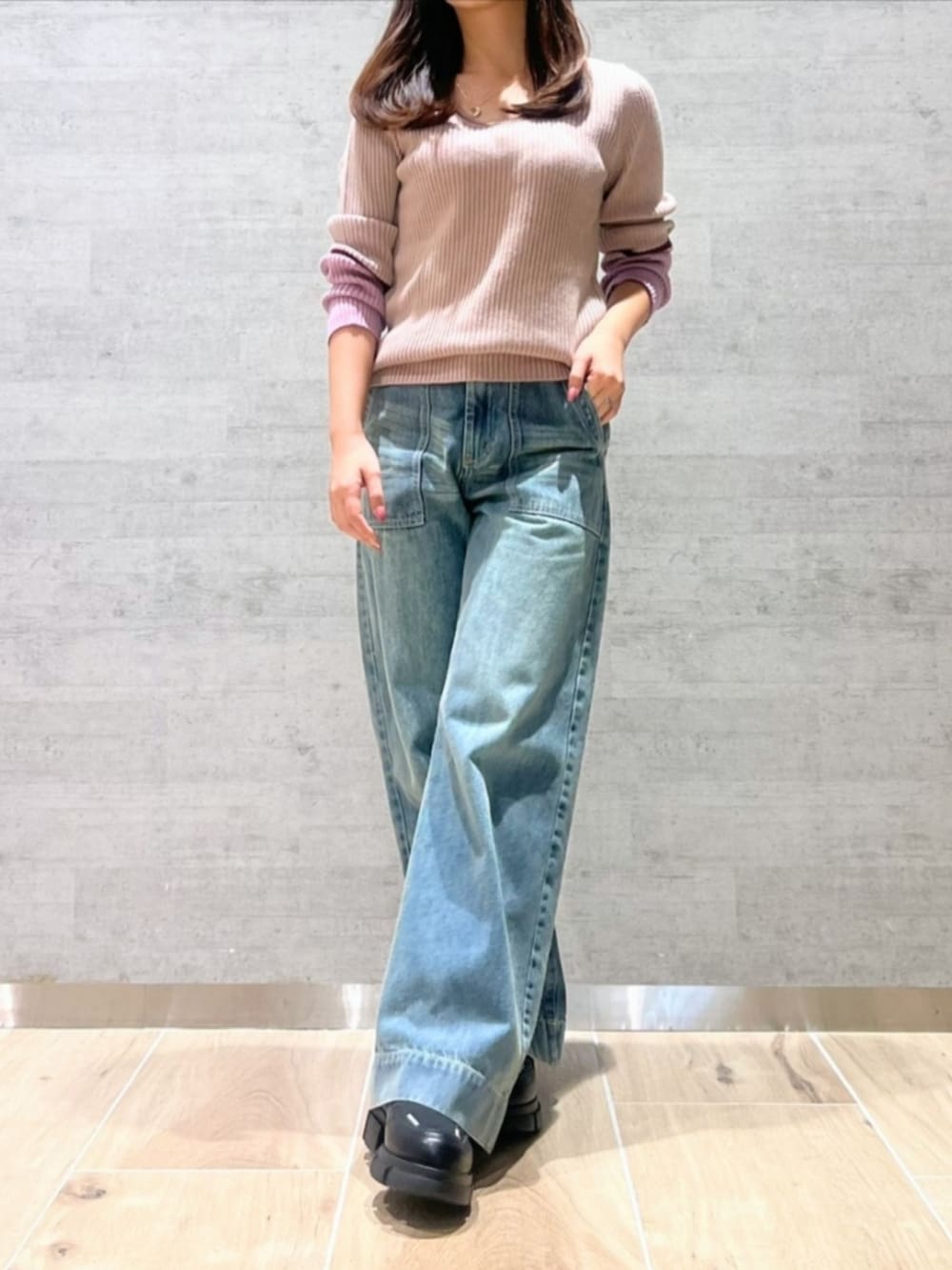 ブルー系のデニムパンツ、ピンク系のニット/セーターを着用したレディースの秋コーディネートの2枚目の写真