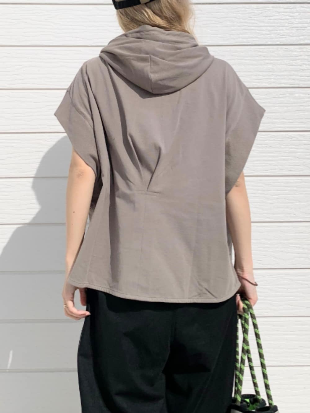 ブラック系のその他パンツ、グレー系のトートバッグ、グリーン系のパーカーを着用したレディースの春コーディネートの5枚目の写真