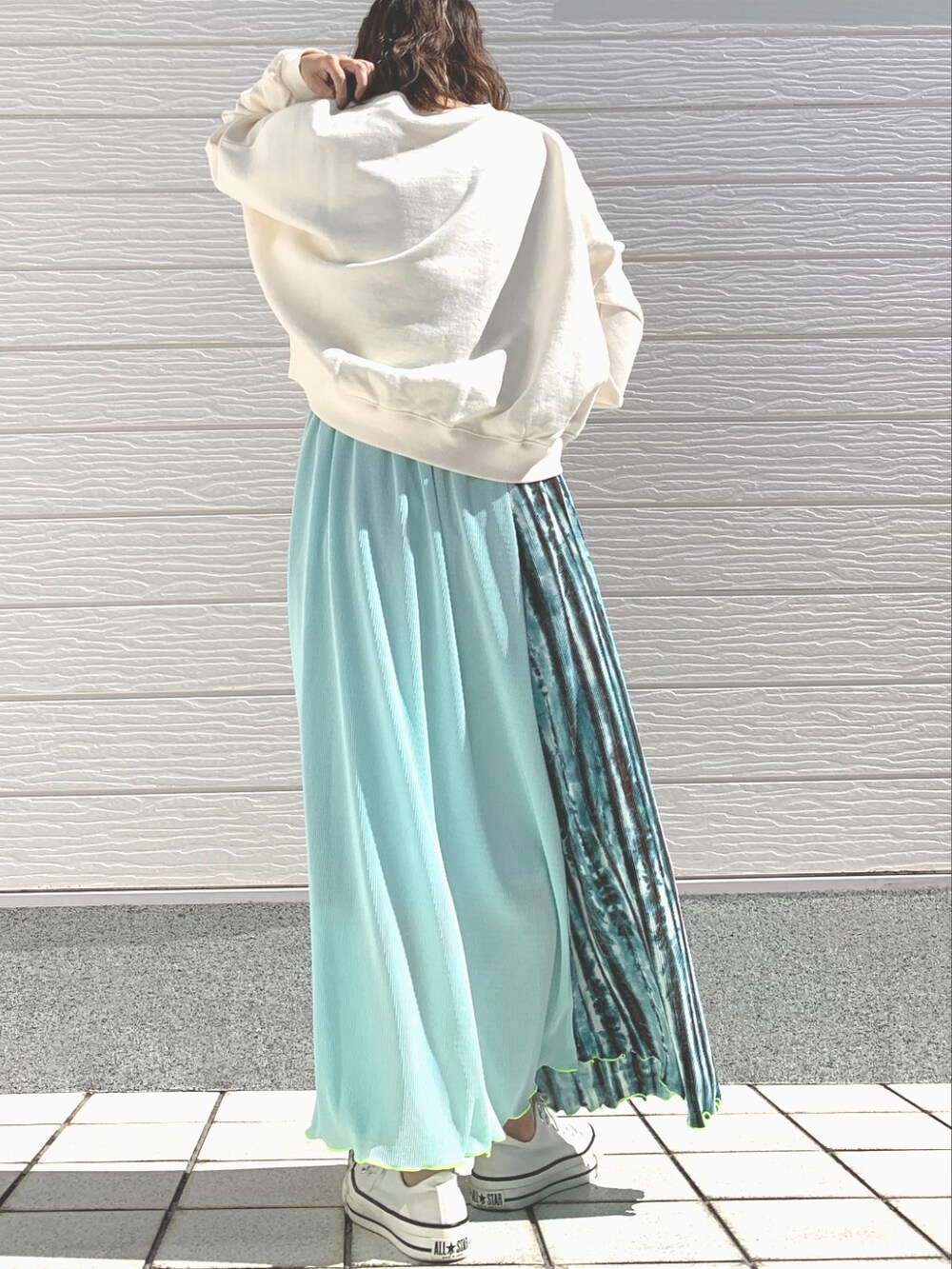 グリーン系のスカート、ホワイト系のスニーカー、ホワイト系のスウェットを着用したレディースの春コーディネートの3枚目の写真