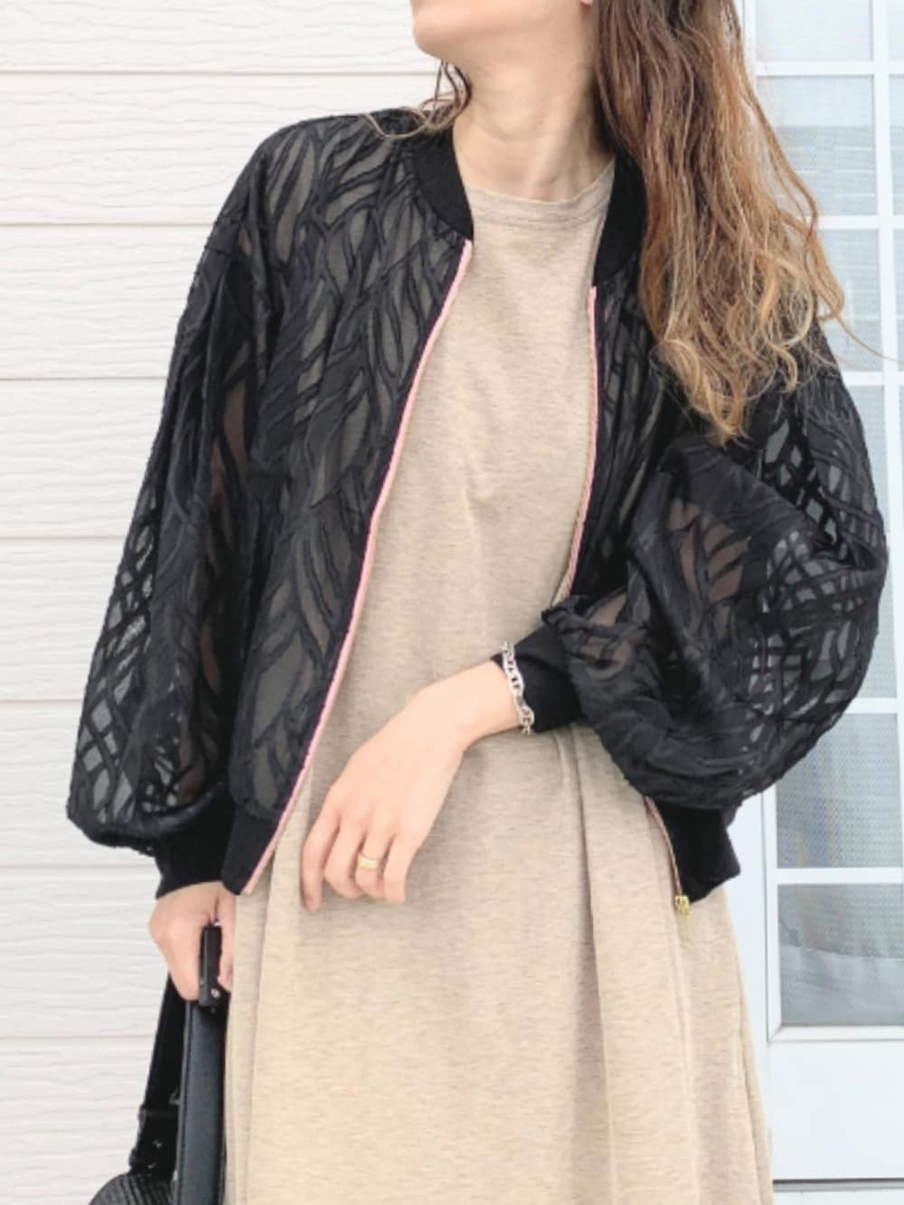 ブラック系のショルダーバッグ、ベージュ系のワンピース、ブラック系のブルゾンを着用したレディースの春コーディネートの5枚目の写真