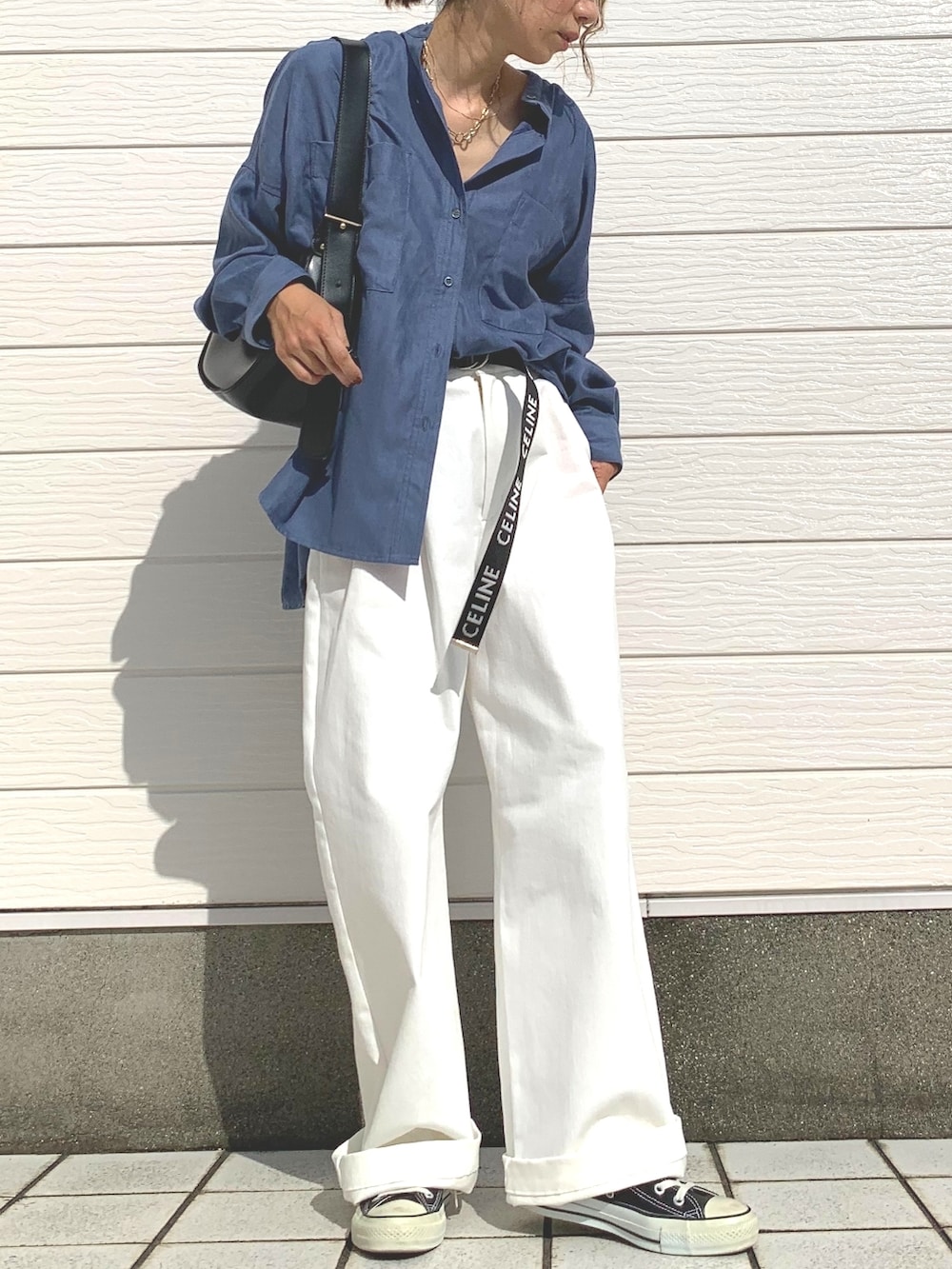 ホワイト系のデニムパンツ、ブラック系のショルダーバッグ、ブラック系のスニーカーを着用したレディースの秋コーディネートの2枚目の写真