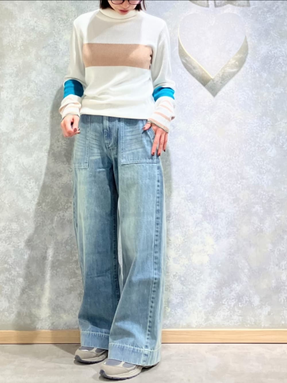 ブルー系のデニムパンツ、ホワイト系のニット/セーターを着用したレディースの冬コーディネートの2枚目の写真