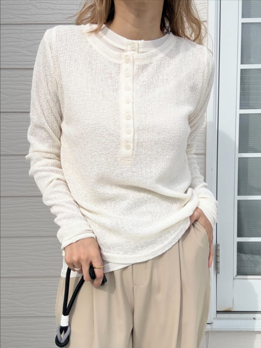 ベージュ系のその他パンツ、ホワイト系のTシャツ/カットソー、イエロー系のサンダルを着用したレディースの冬コーディネートの3枚目の写真