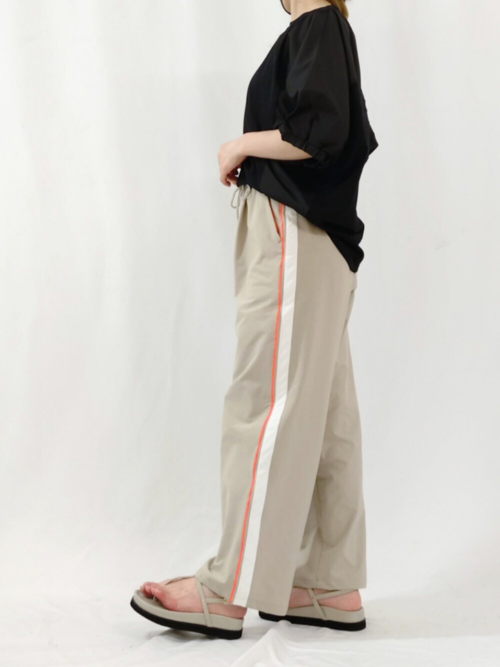 ベージュ系のその他パンツ、ブラック系のTシャツ/カットソー、グレー系のサンダルを着用したレディースの春コーディネートの4枚目の写真