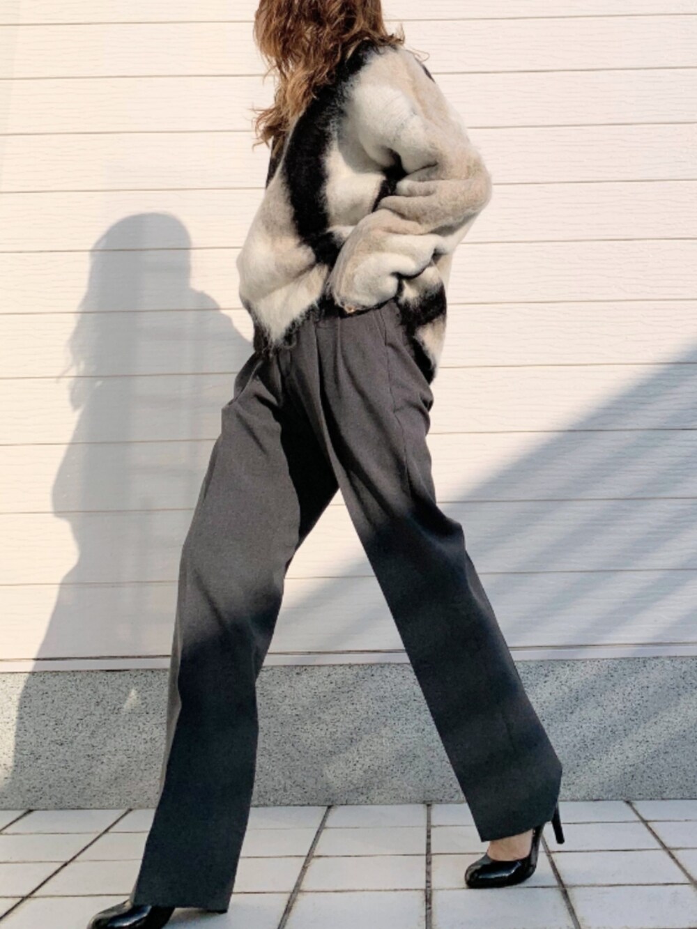 ブラック系のニット/セーター、ピンク系のショルダーバッグ、グレー系のその他パンツを着用したレディースの秋コーディネートの2枚目の写真