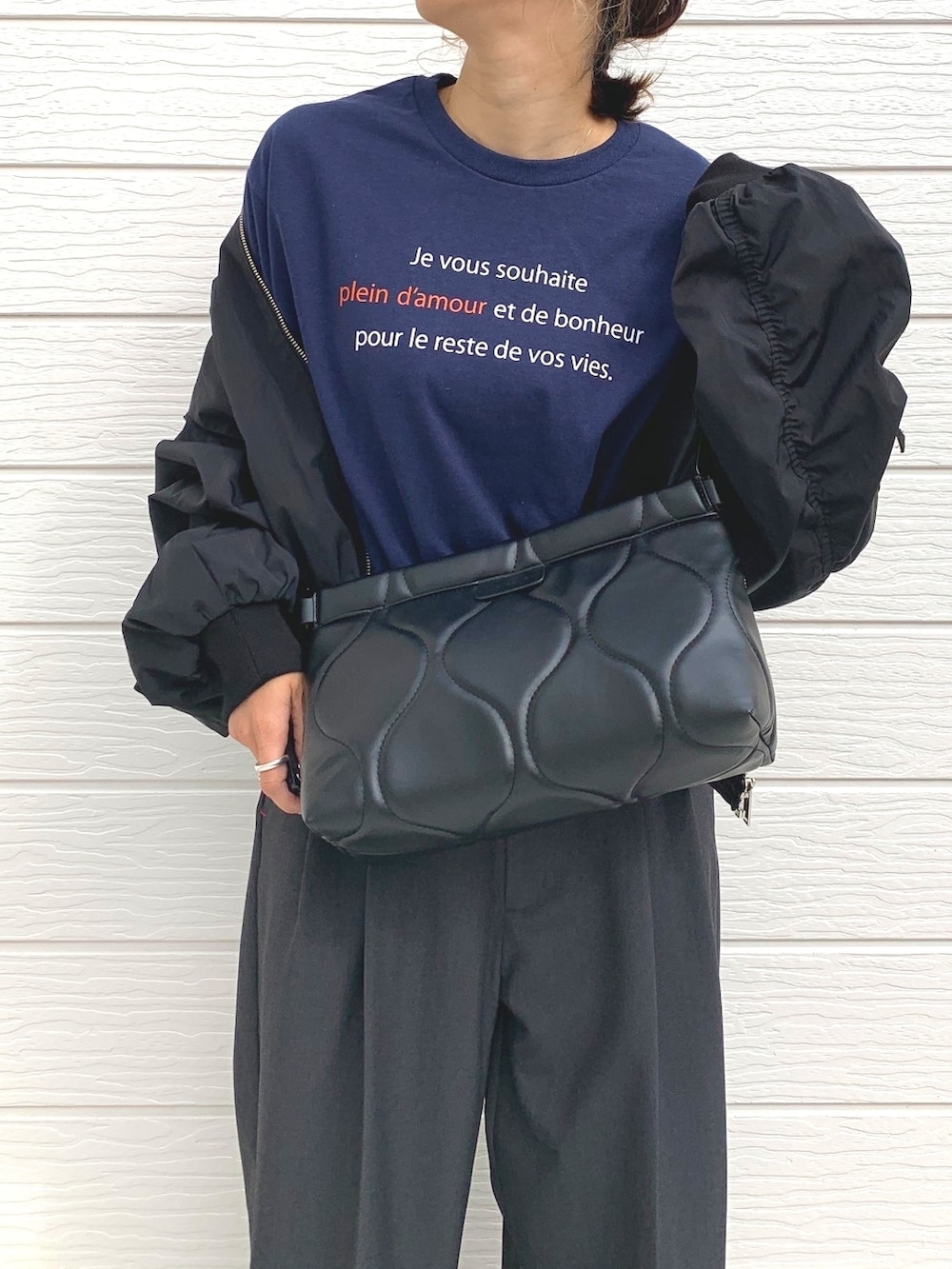 ブラック系のブルゾン、ブルー系のTシャツ/カットソー、シルバー系のスニーカーを着用したレディースの秋コーディネートの3枚目の写真
