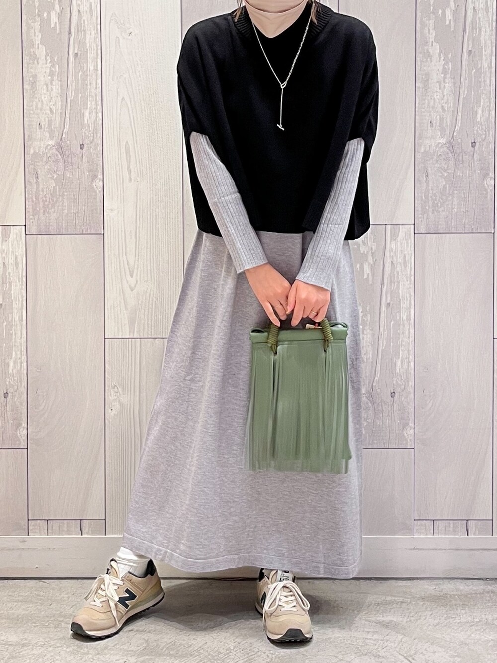 グリーン系のショルダーバッグ、グレー系のワンピースを着用したレディースの秋コーディネートの2枚目の写真