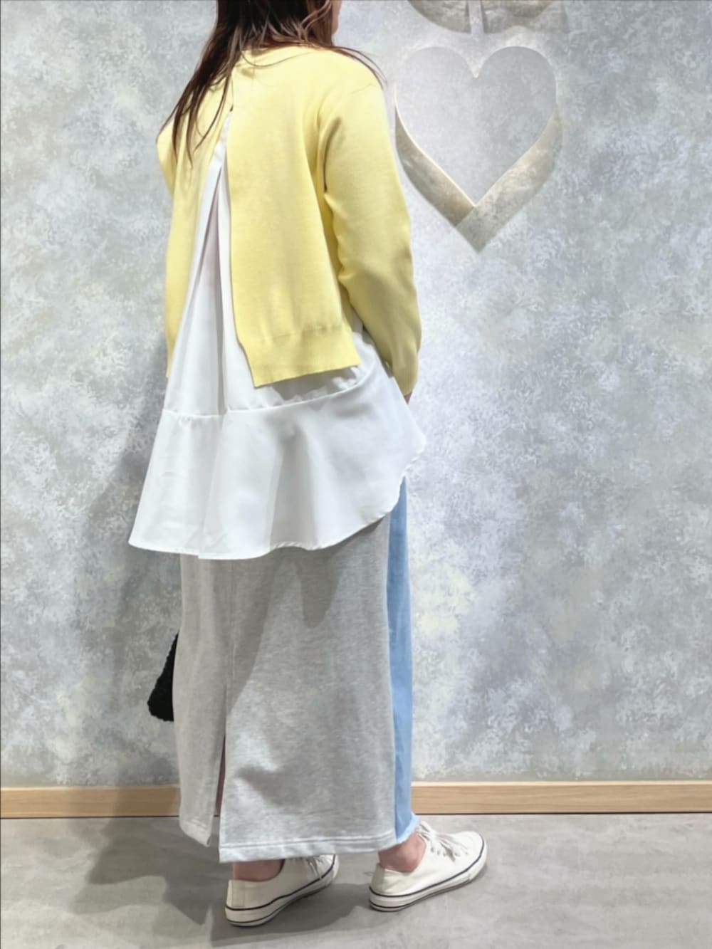 ブルー系のスカート、ブラック系のトートバッグ、イエロー系のニット/セーターを着用したレディースの冬コーディネートの3枚目の写真