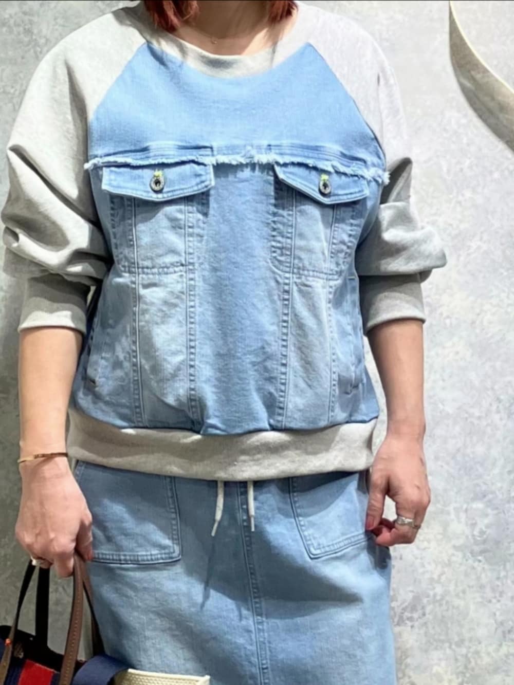 ブルー系のスカート、ブルー系のスウェット、シルバー系のスニーカーを着用したレディースの冬コーディネートの4枚目の写真