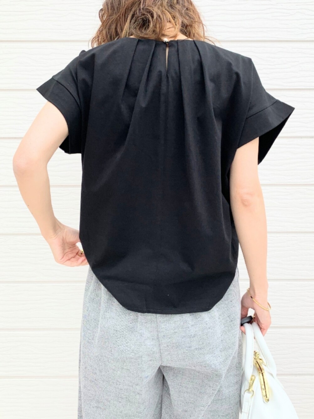 ブラック系のTシャツ/カットソー、ホワイト系のショルダーバッグ、グレー系のその他パンツを着用したレディースの春コーディネートの5枚目の写真