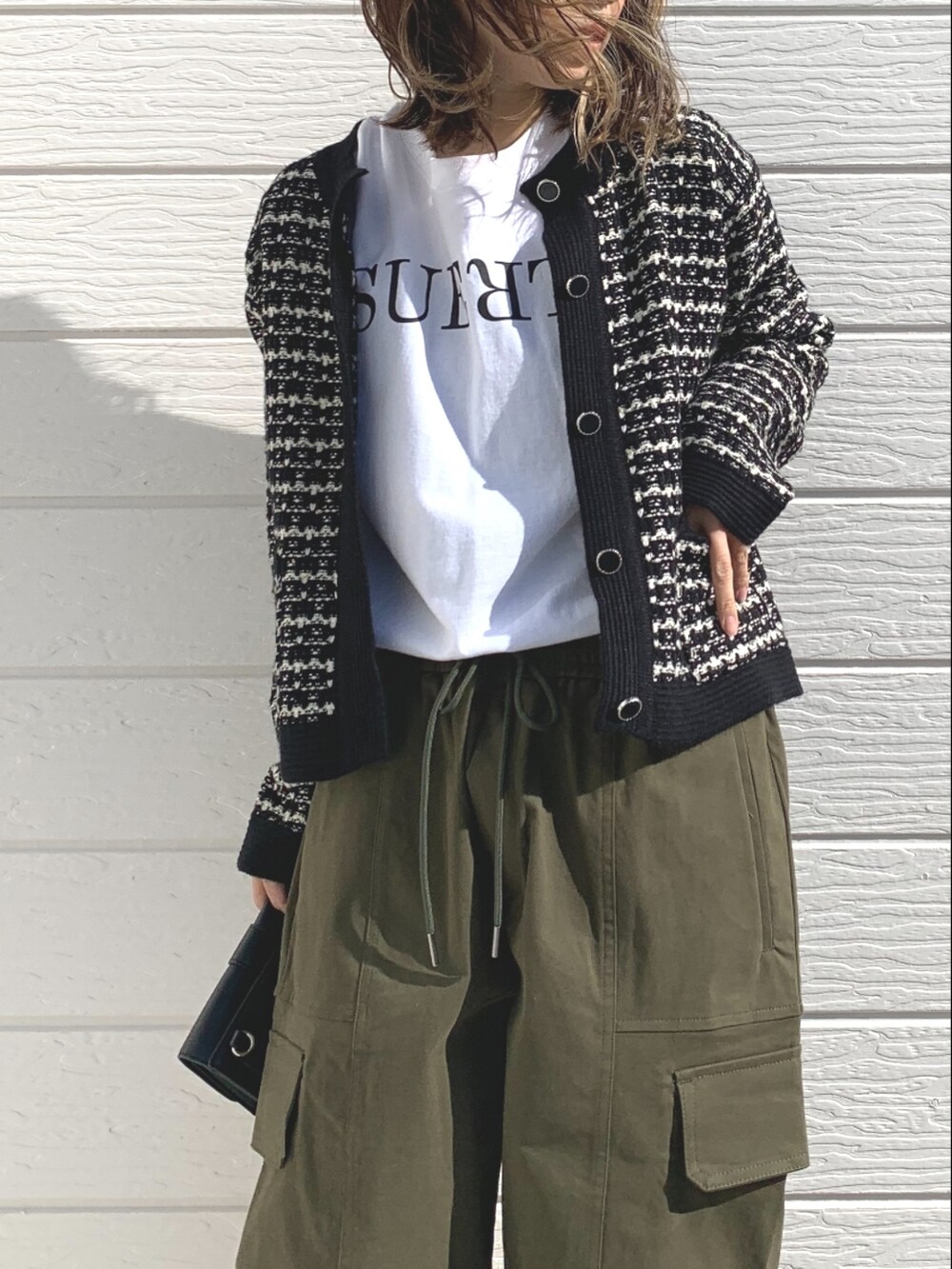 グリーン系のその他パンツ、ブラック系のカーディガン/ボレロ、ホワイト系のTシャツ/カットソーを着用したレディースの冬コーディネートの3枚目の写真