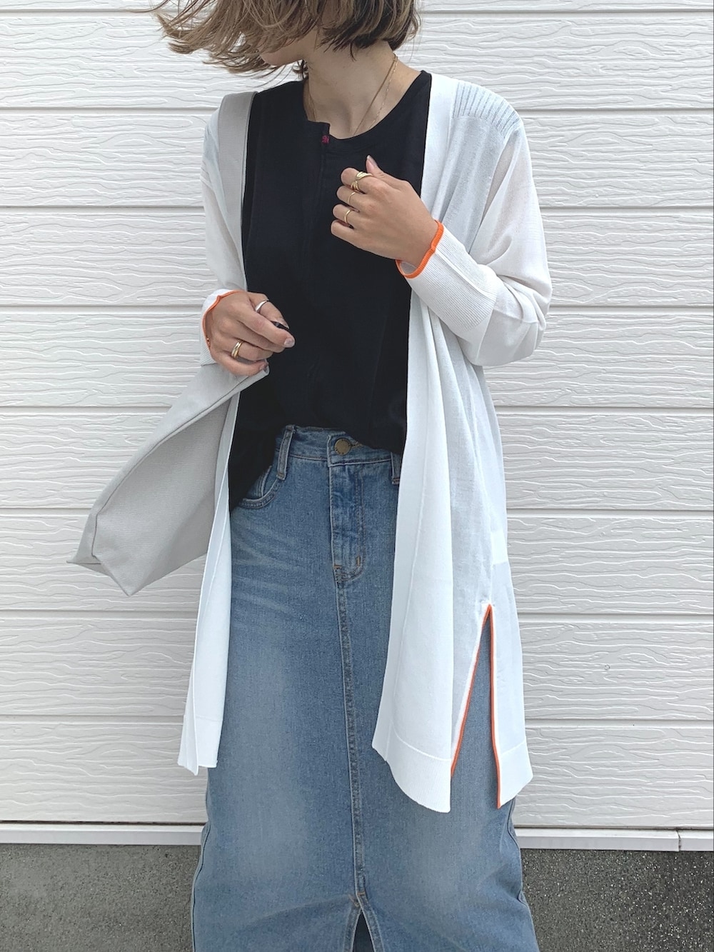 ブルー系のデニムスカート、ブラック系のサンダル、グレー系のトートバッグを着用したレディースの夏コーディネートの2枚目の写真