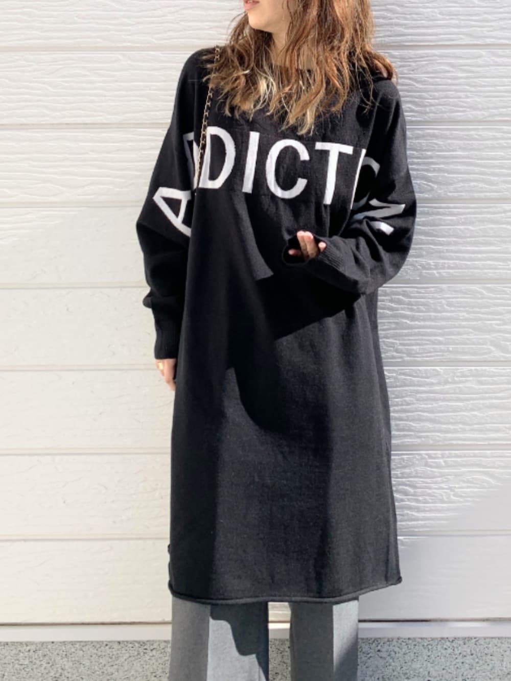 グレー系のその他パンツ、ホワイト系のスニーカー、ブラック系のニット/セーターを着用したレディースの冬コーディネートの3枚目の写真