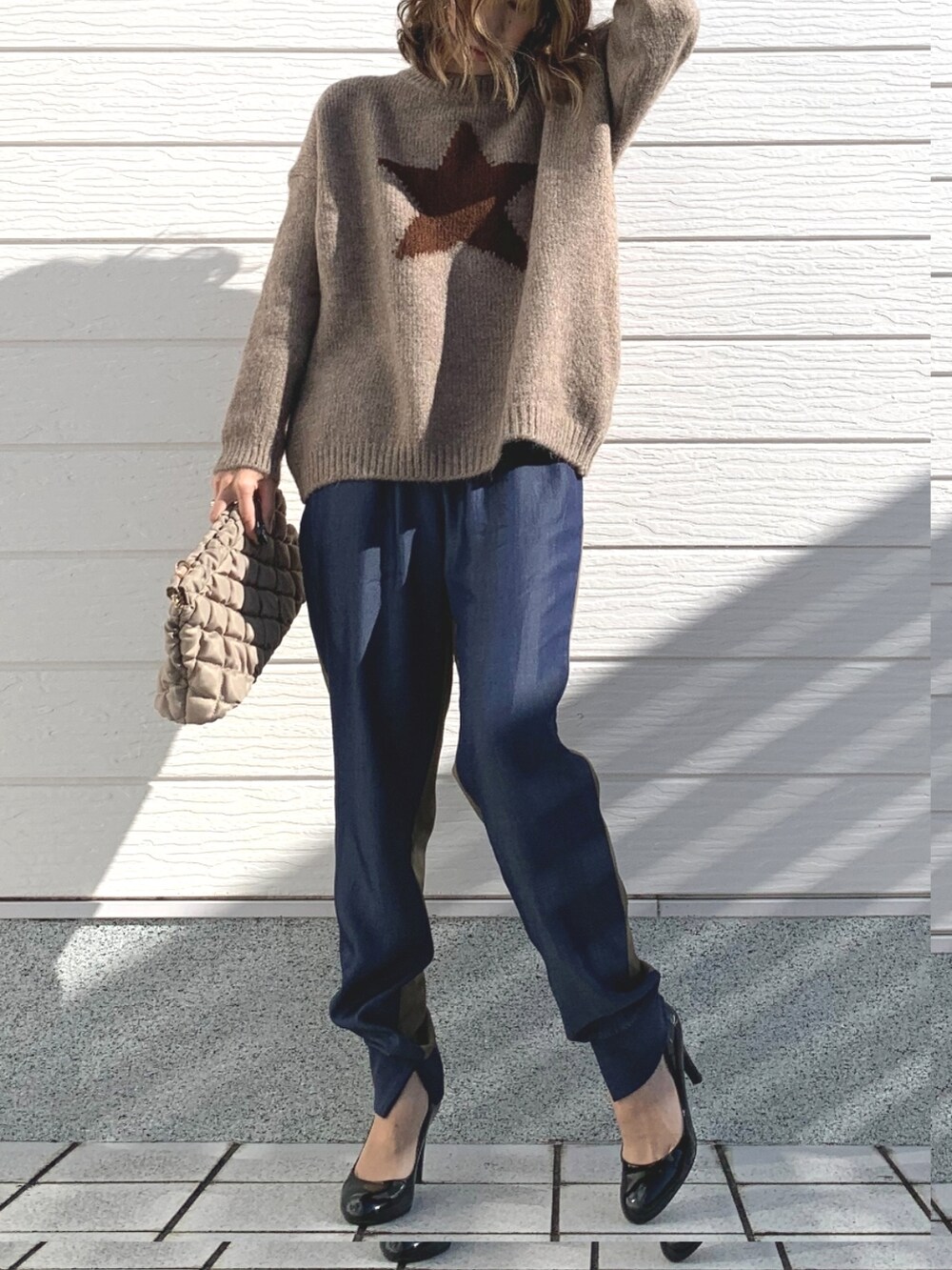 グリーン系のデニムパンツ、グレー系のニット/セーター、ベージュ系のショルダーバッグを着用したレディースの冬コーディネートの2枚目の写真