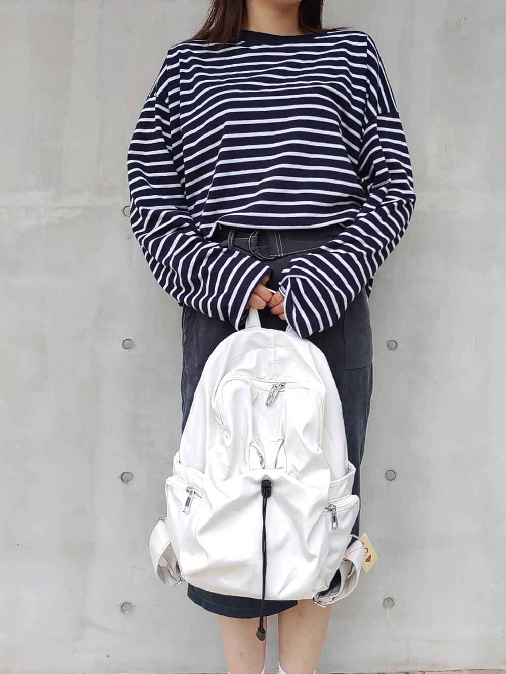 ブルー系のTシャツ/カットソー、ホワイト系のバックパック/リュック、ホワイト系のスニーカーを着用したレディースの秋コーディネートの4枚目の写真