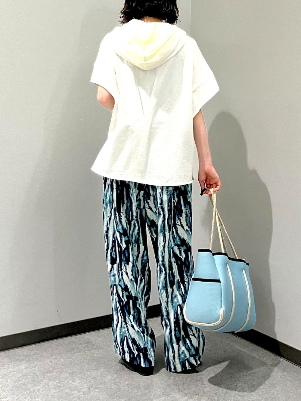 ブルー系のその他パンツ、ホワイト系のパーカー、ブルー系のトートバッグを着用したレディースの夏コーディネートの5枚目の写真