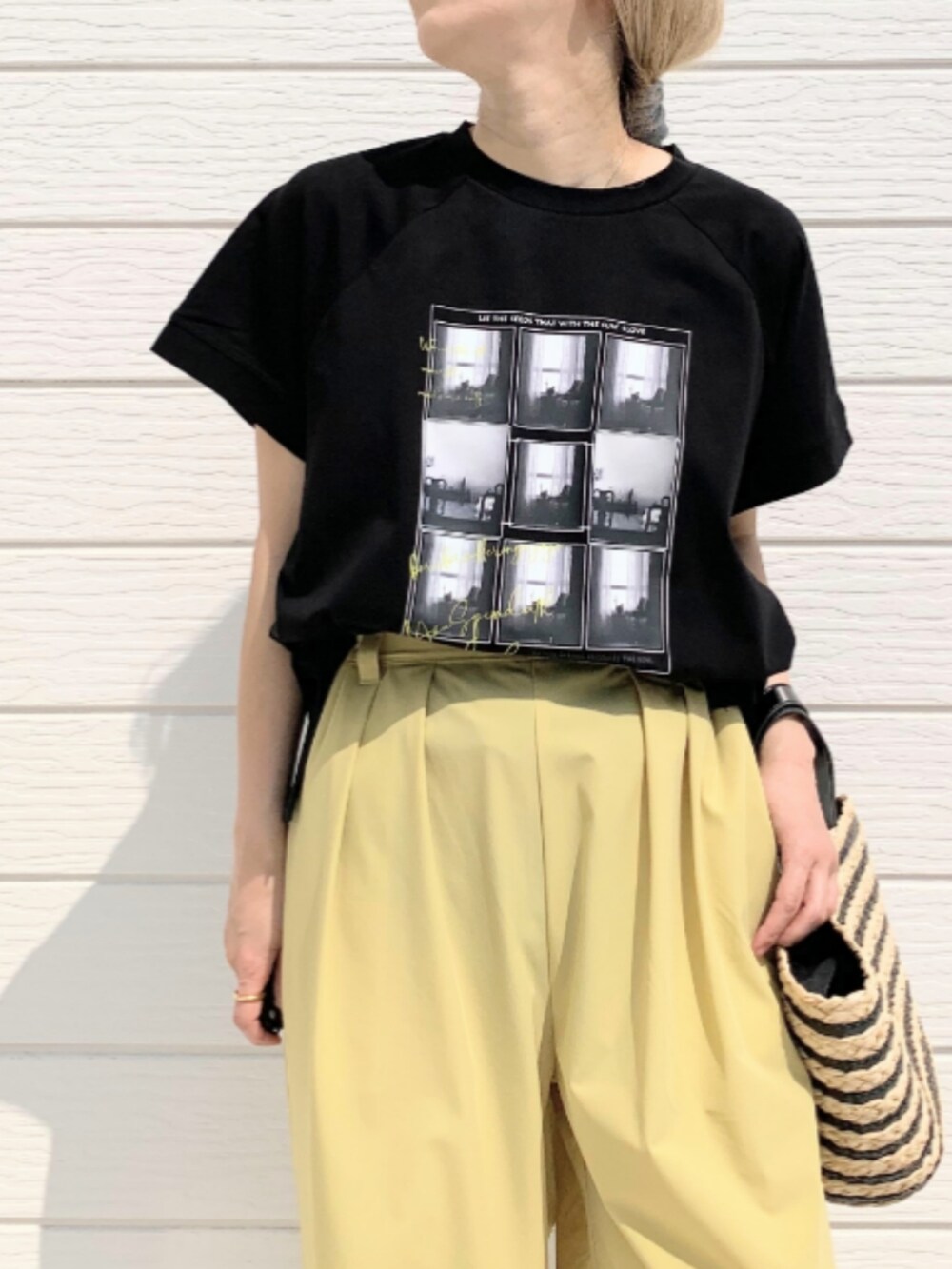 ブラック系のかごバッグ、イエロー系のその他パンツ、ブラック系のTシャツ/カットソーを着用したレディースの春コーディネートの4枚目の写真