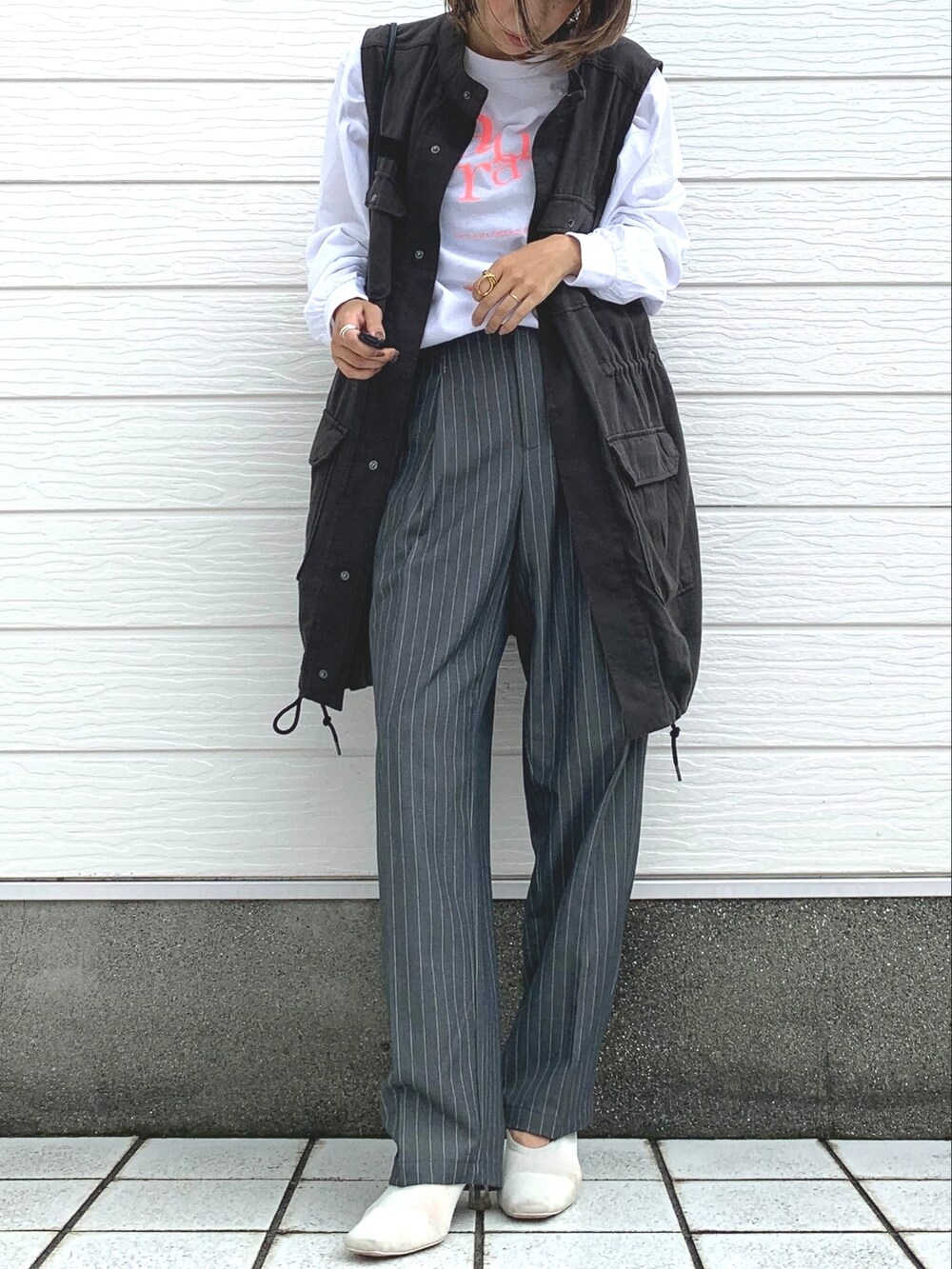 ブラック系のベスト、ホワイト系のTシャツ/カットソー、グレー系のその他パンツを着用したレディースの秋コーディネートの2枚目の写真