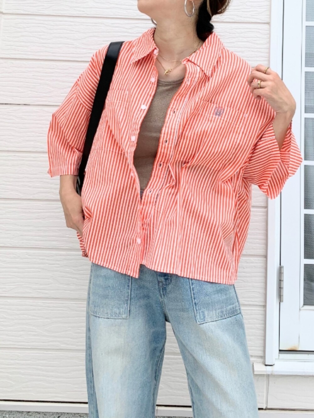 ブルー系のデニムパンツ、ベージュ系のタンクトップ、オレンジ系のシャツ/ブラウスを着用したレディースの夏コーディネートの3枚目の写真