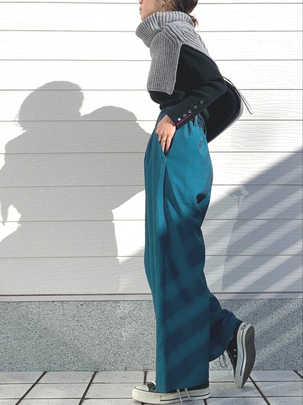 ブルー系のその他パンツ、ブラック系のショルダーバッグ、ブラック系のニット/セーターを着用したレディースの冬コーディネートの2枚目の写真