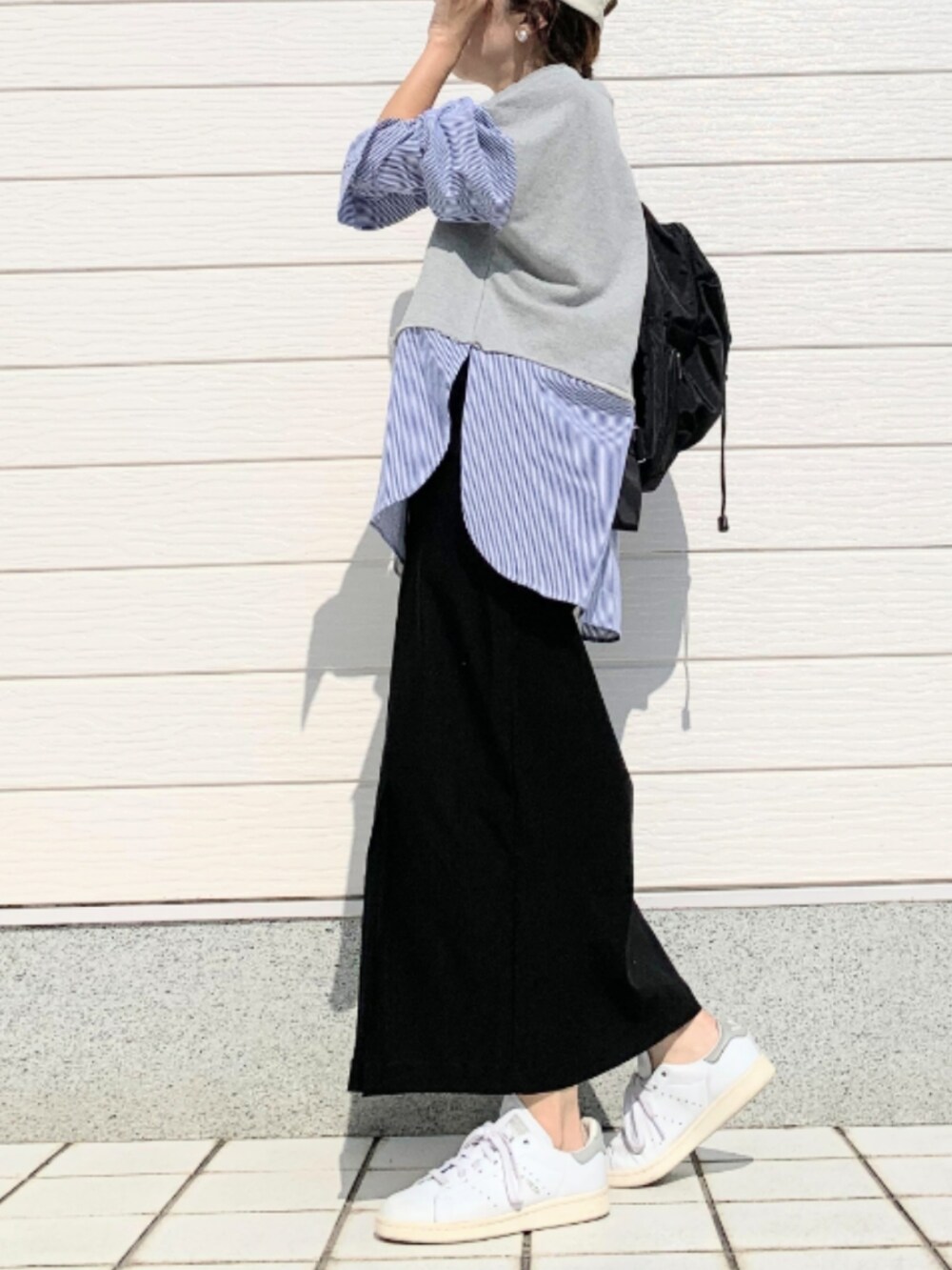 ホワイト系のスニーカー、ブラック系のスカート、ブラック系のバックパック/リュックを着用したレディースの夏コーディネートの2枚目の写真