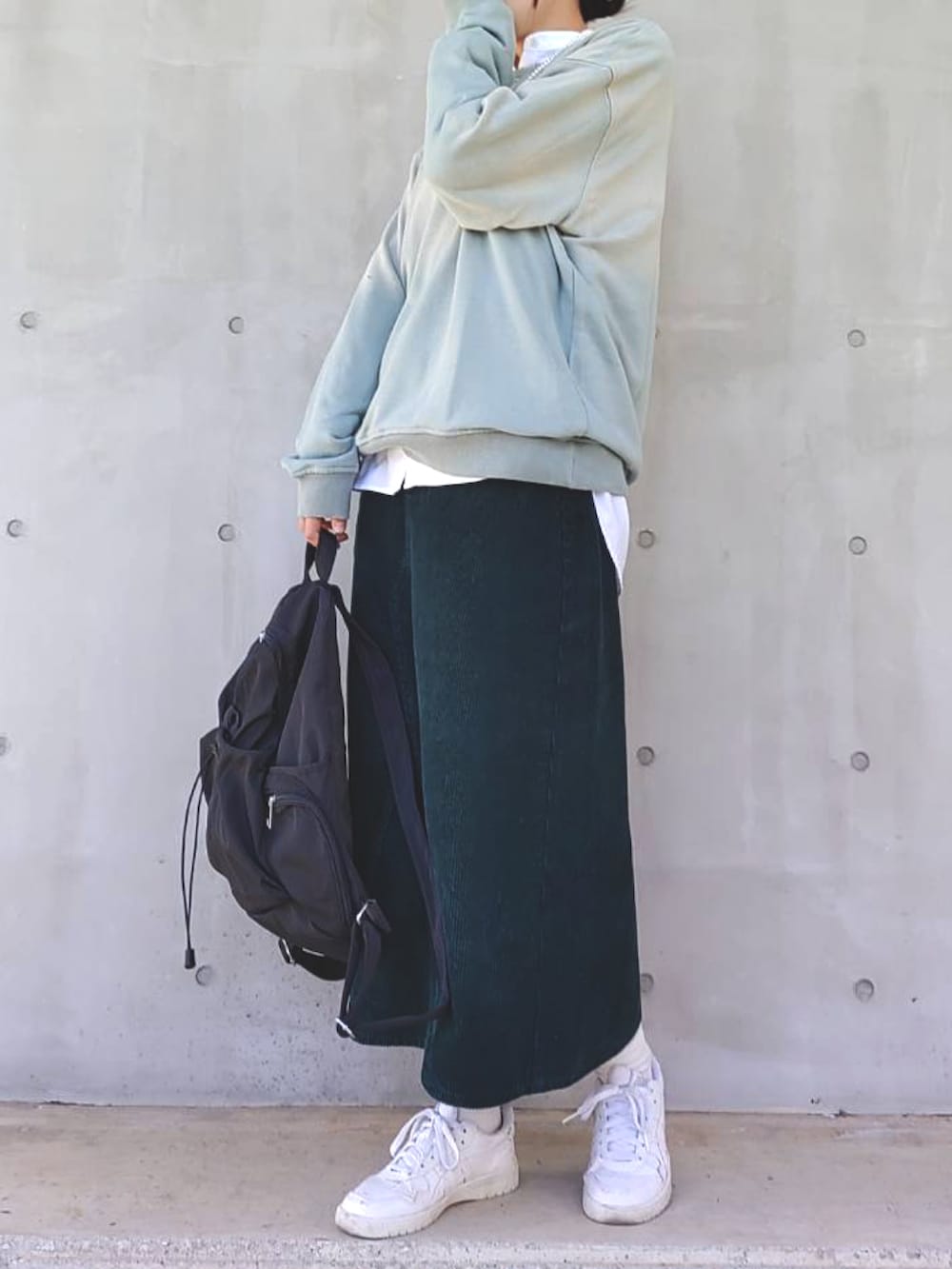 グリーン系のスウェット、ホワイト系のシャツ/ブラウス、グリーン系のスカートを着用したレディースの冬コーディネートの2枚目の写真