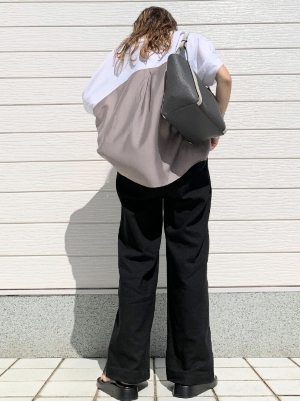 ブラック系のその他パンツ、グレー系のトートバッグ、ホワイト系のTシャツ/カットソーを着用したレディースの春コーディネートの3枚目の写真
