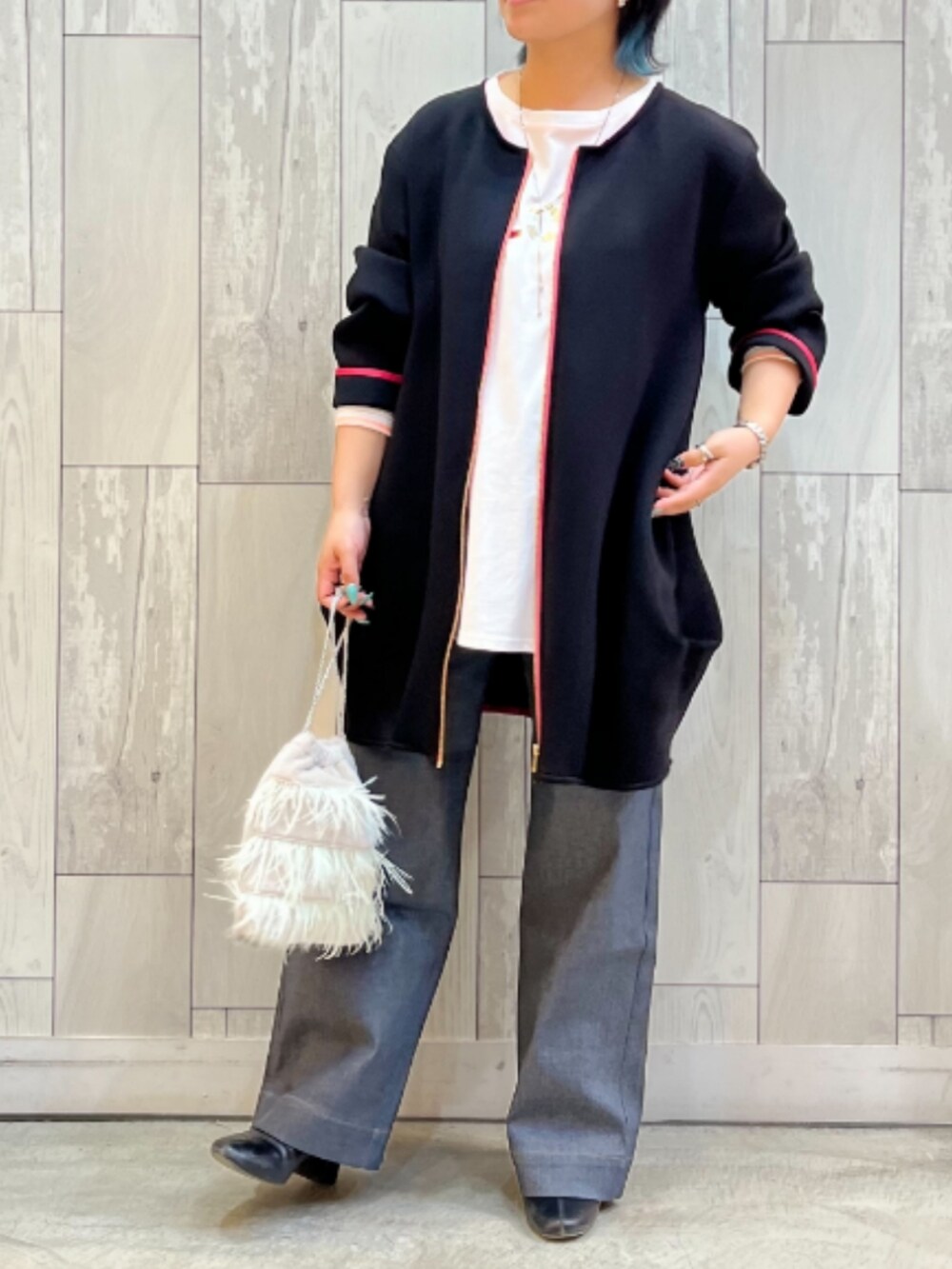 グレー系のデニムパンツ、グレー系のクラッチバッグ、ホワイト系のTシャツ/カットソーを着用したレディースの秋コーディネートの2枚目の写真